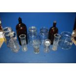A collection of glass containers, including three laboratory cylinders,