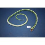 A green and white beaded snake, 53'' long approx.