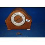 A wooden mantle Clock with beige face and gilt numbers, with key.