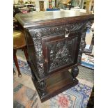 A dark Oak Continental Cupboard having a frieze drawer flanked by lion masks,