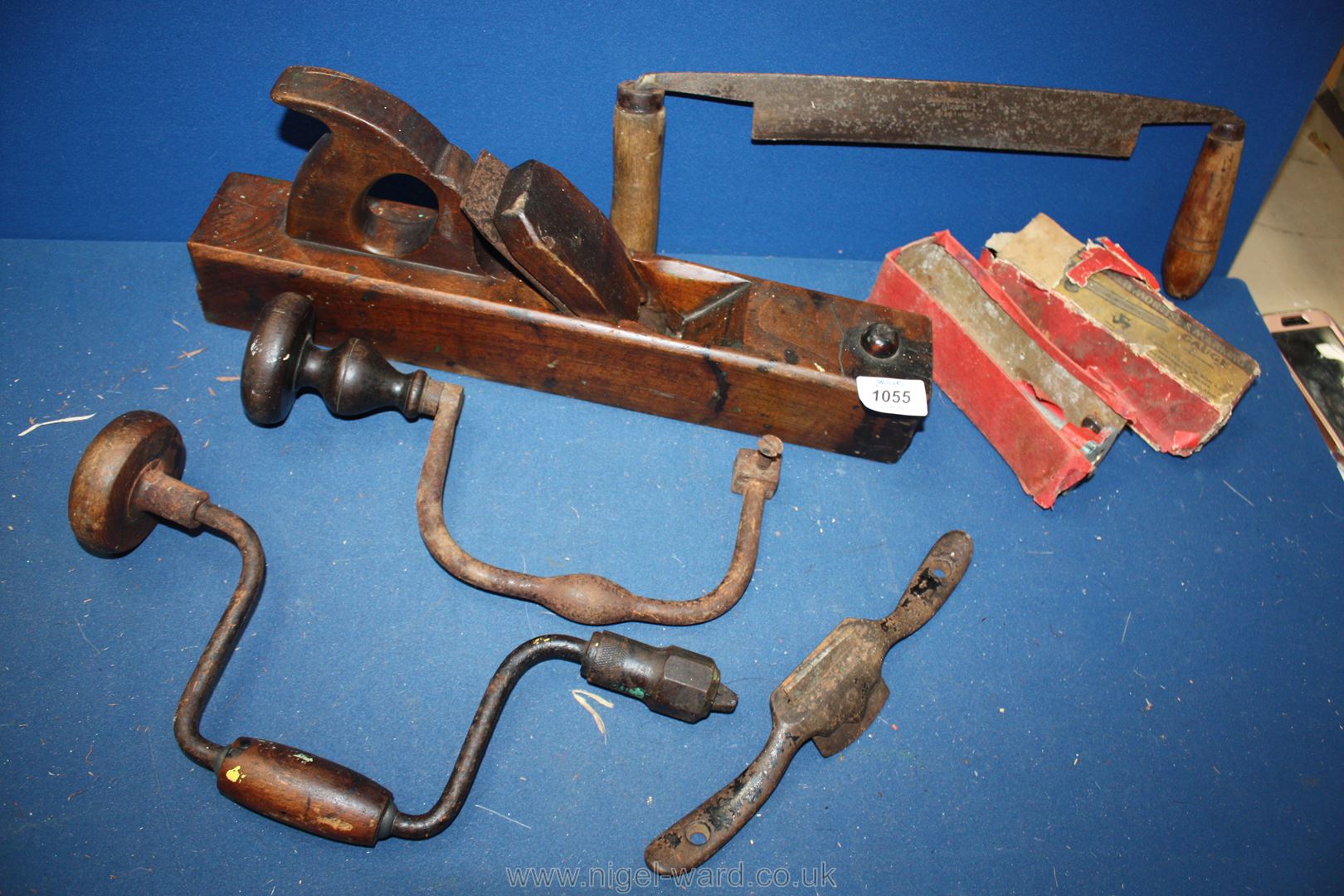 A box of early 20th Century woodworking tools; brace and bit, plane, draw knife, etc.