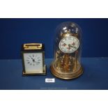 A glass domed anniversary Clock along with a Timemaster carriage clock.