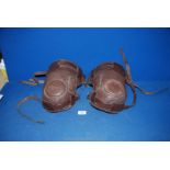 A pair of brown leather two strap knee pads for horse riding/polo.