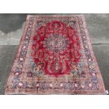 A large woolen hand-made red Mashad Carpet, 375 x 278 cm.