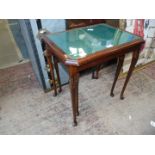 A nest of two green and glass topped Mahogany occasional tables on cabriole legs.