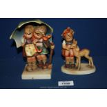 Two Goebel Hummel figures of two children under an umbrella and a little girl with a deer,