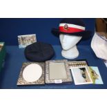A box containing two Red Cross hats and two white metal frames.