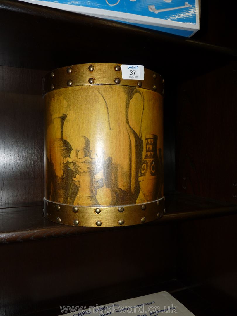 A wooden decorated waste bin.