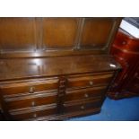 An Ercol dark-wood dresser with drinks compartment shelving and six drawers.