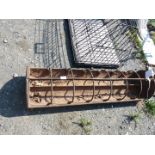 A cast iron piglet feeder/trough with dividing bars.