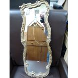 A gilt framed abstract shaped mirror.