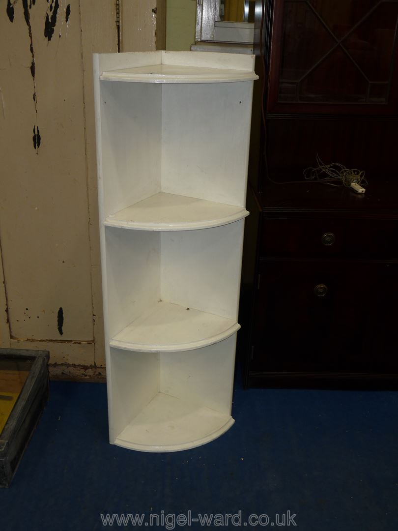 A small painted corner unit having three shelves.