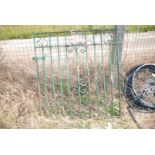 A green wrought iron garden gate.