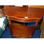 A cross-banded shaped hall table with drawer and lower shelf.