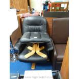 A faux leather swivel black chair and foot stool.