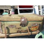 An old canvas and leather travel trunk containing an antique distressed butler bell-board.