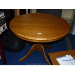 A circular Oak finished kitchen table, 39" diameter.