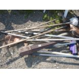 A quantity of garden tools, rakes, brushes,