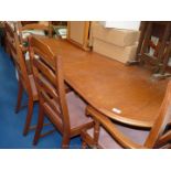 An extending oval Oak finished dining table and six chairs.