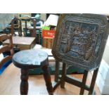 A small ornate flip top table with oriental top and a small stool.