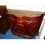 A reproduction bow-fronted sideboard.