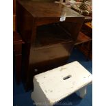 A dark-wood bedside cabinet and a foot stool.