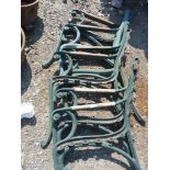 Three pairs of cast iron bench ends with wooden arms.