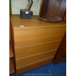 A light Oak finished chest of four long drawers.