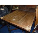 A square draw-leaf table on twist legs, top distressed.