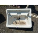 A vintage white wash hand basin with taps.