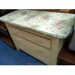A cream painted dressing table/chest of three drawers with glass top.