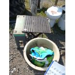 A collapsible wooden table, large flower pot and a plastic garden kneeler.