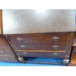 An Oak bureau having a light Oak finished interior and with three long drawers below and standing