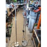 Two tall floor lamps, one with three LED lights, chrome circular base and upright,