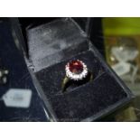 A 9 ct garnet and diamond ring hallmarked size 'R 1/2'.