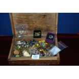 A wooden box with brass detail with mixed jewellery, earrings, rings, brooches etc.
