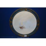 A blue and gilt circular framed watercolour depicting oriental boats;