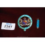 A 'sterling' enamelled cap badge and an engine turned turquoise enamelled pull action compact