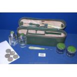 A green leather oblong Vanity case with green enamel contents, bottles,