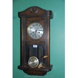 A wooden cased wall Clock with Arabic numerals on silver coloured face and glass panels to the door,