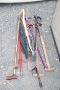 Quantity of garden spades, forks and walking sticks.