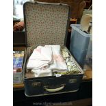 Travel case containing a good quantity of colourful table linen etc