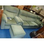 A Parker Knoll three piece suite and matching foot stool in green fabric.