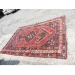 Triple bordered rug with lozenge design centre tribal pattern and tassel ends (has holes) a/f.