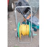 Garden hose on reel type stand.