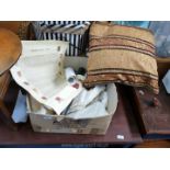 Box of cream coloured linen and cushion with tassels.