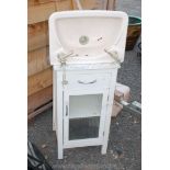 Glazed fronted bathroom cabinet and hand basin.