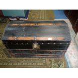A black domed travel Trunk with brass studs, 32'' long x 19'' x 21''.