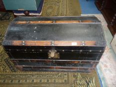 A black domed travel Trunk with brass studs, 32'' long x 19'' x 21''.