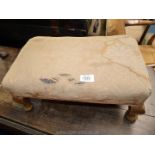 A rectangular beige upholstered (stained) Stool standing on brief cabriole legs,